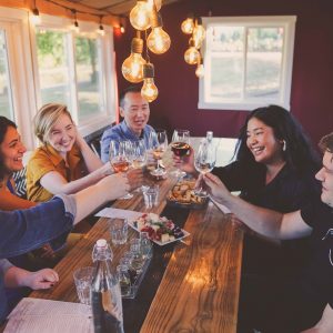 A group of people cheers-ing with wine glasses